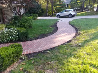 Curved red brick front walkway leading to a classic Kansas City home